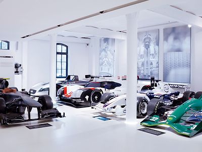  Fünf verschiedene Rennwagen in weißem Ausstellungsraum