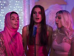  Drei junge Frauen singen auf einer Hochzeit gemeinsam in ein Mikrofon.