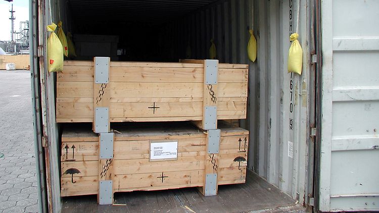 Ein offener Container mit Holzbarren drin.