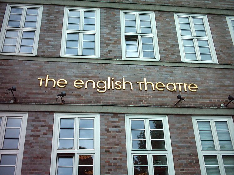  Die gemauerte Außenwand des English Theatre, mit dem Namen des Theaters in Gold.