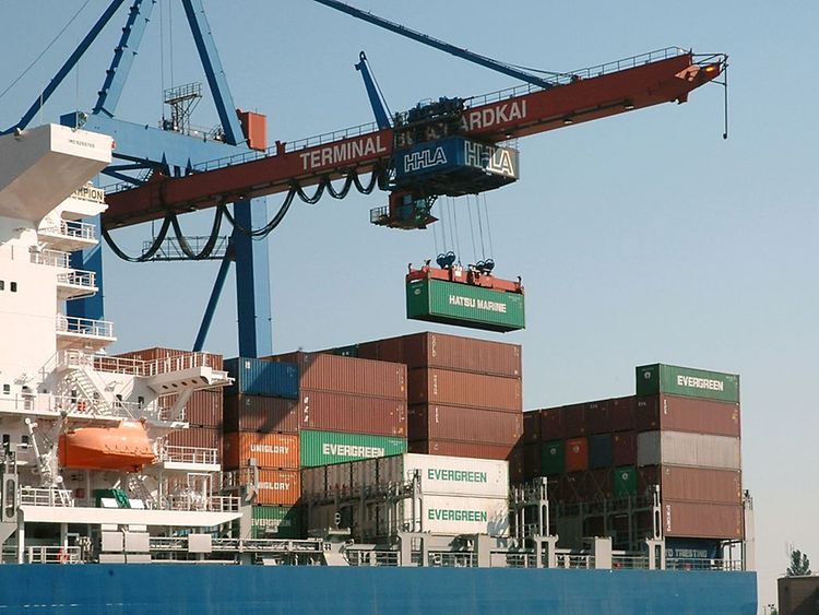  Ein Hafenkran verfrachtet Container auf ein Schiff