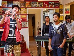  Jugendliche Musikgruppe mit Sänger mit Baseballcap vor Mikrophon