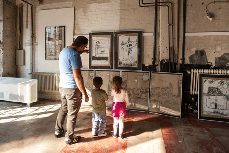 Ein Vater betrachtet mit seinen zwei kleinen Kindern die Bilder der Ausstellung auf dem Forum Flüchtlingshilfe 2016 