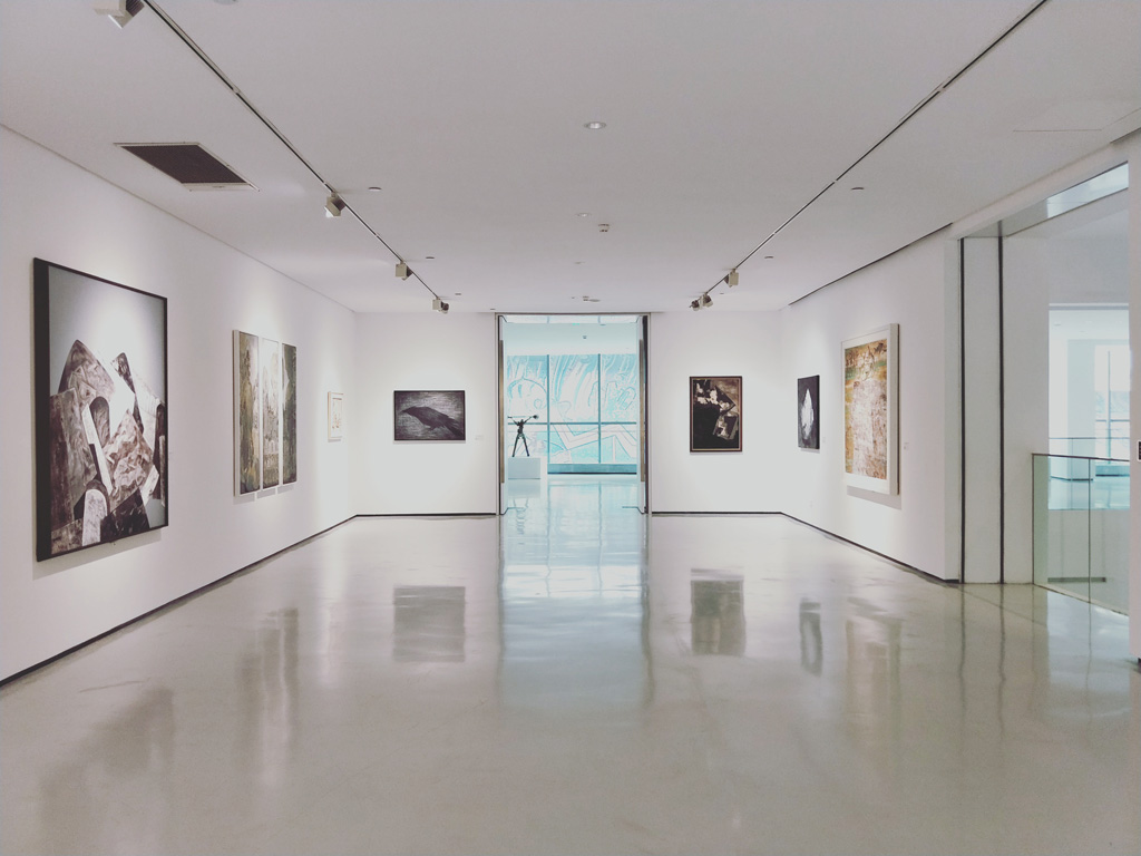 Ein leerer heller Raum im Museum mit Bildern an den Wänden.