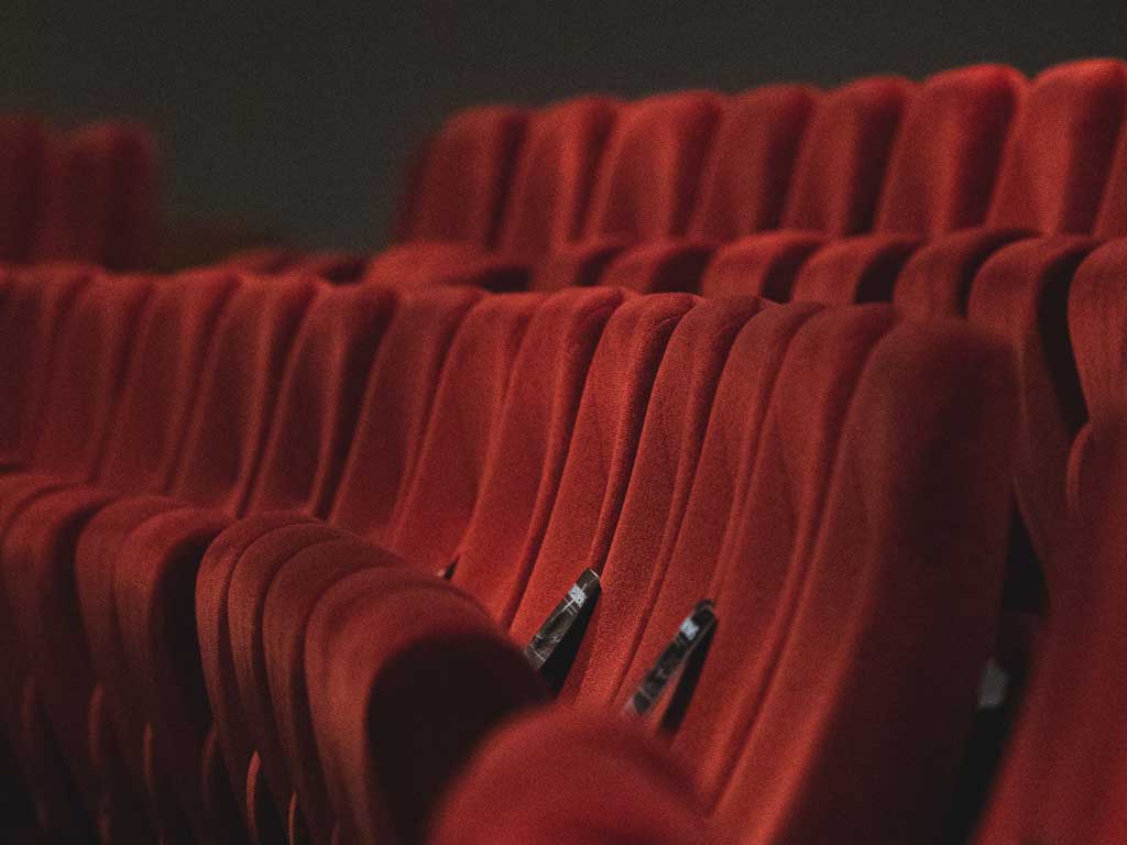 Rote Sessel stehen in einer Reihe hintereinander. 