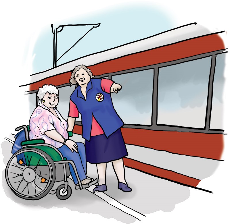 Eine Frau von der Bahnhofsmission hilft einer Frau im Rollstuhl