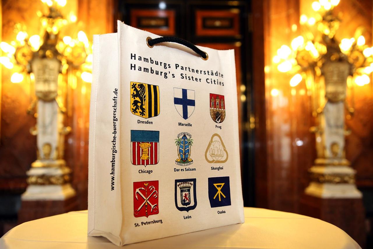 Tragetasche, auf der die Wappen aller neun Partnerstädte Hamburgs gedruckt sind. 