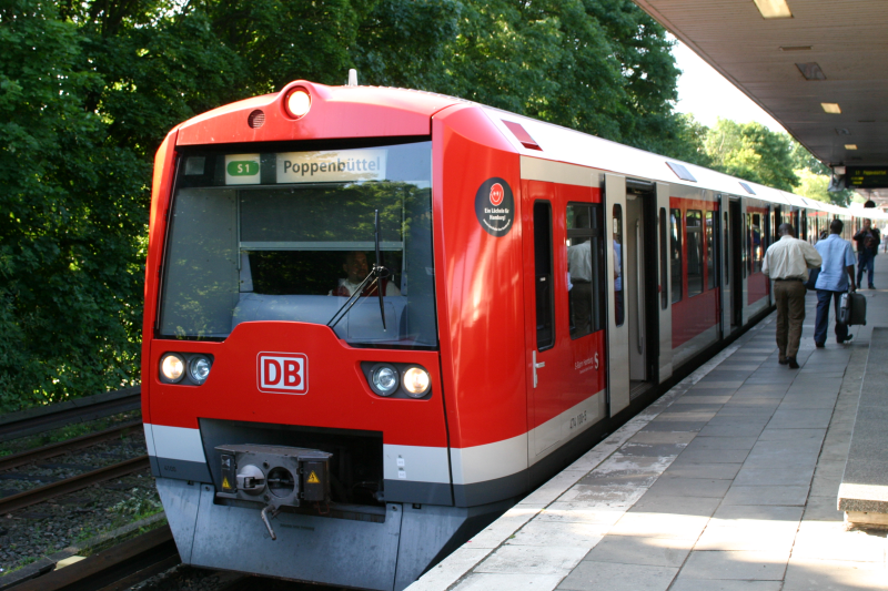 Eine rote S-Bahn hält vor einem Bahnsteig.