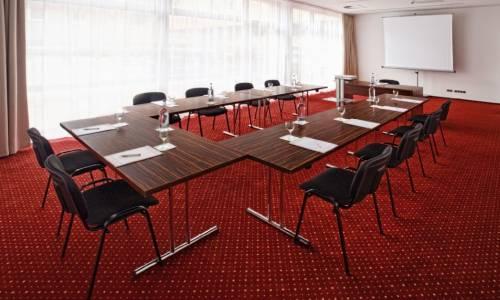 Konferenzraum mit Tisch und Stühlen und rotem Teppich