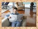 Ein Mann liest in einer Zeitung auf einem Sofa
