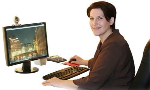 Mitarbeiterin beim Arbeiten vor einem Computer und weißem Hintergrund