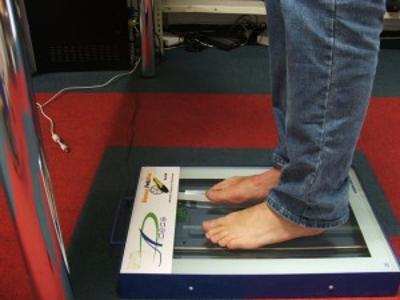 Ein Mensch steht mit nackten Füßen auf einem Messgerät