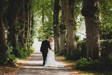Andrea Scheib Hochzeitsfotografie - Brautpaar geht Allee entlang