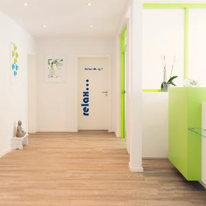 Heller Holzfußboden, weiße Wände und ein grüner Tresen