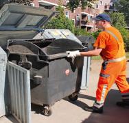 HEG-Mitarbeiter arbeitet an Müllcontainer