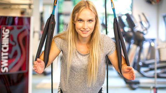 Eine Frau trainiert an einem Fitnessgerät