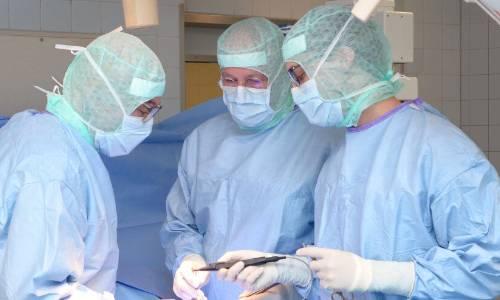 Drei Chirurgen im OP-Kittel