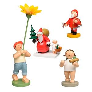 Vier kleine Figuren, ein Junge mit einer Blume, ein Engel und zwei Weihnachtsmänner