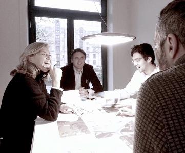 Teamfoto der Agentur GEYER M&K, drei Männer und eine Frau sitzen um einen Tisch