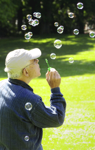 Älterer Mann macht Seifenblasen