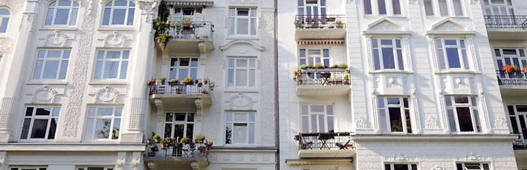 Blick auf ein weißen Altbau mit vielen Balkonen