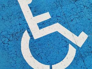 Weißes Rollstuhlfahrerzeichen auf blauem Untergrund