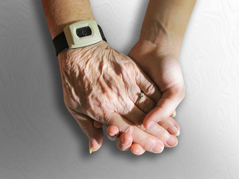 Eine ältere und eine jüngere Hand halten sich