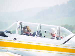 Zwei Personen sitzen hintereinander in einem Segelflugzeug