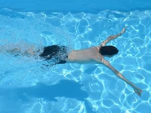 Mann schwimmt in einem Pool