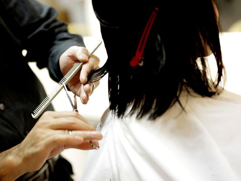 Einer Frau werden die Haare geschnitten.