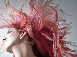 Eine Frau wirbelt ihre roten Haare hin und her.