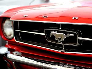 Silbernes Pferd auf dem Kühler eines roten Ford Mustang