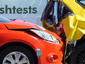 Autounfall, ein rotes Auto fährt einem gelben Auto hinten auf