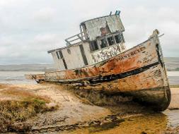 Ein altes Schiffswrack liegt auf dem Sandstrand