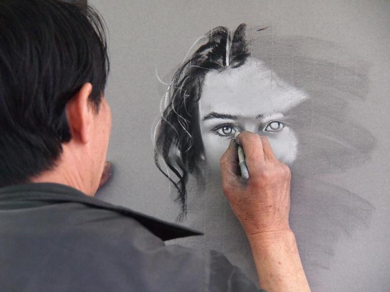 Ein Mann malt das Gesicht einer Frau