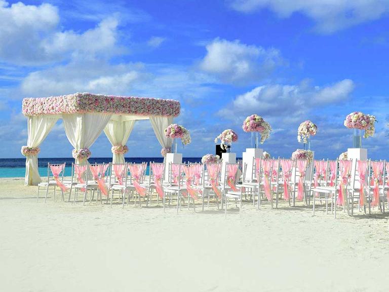Ein geschmückter Pavillon und Stühle am Strand