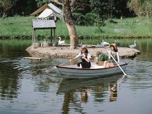 Zwei Frauen sitzen in einem weißen Holzboot und fahren auf einem See