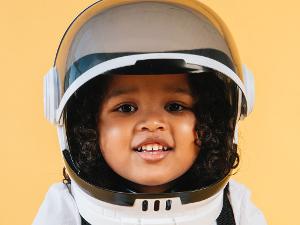 Ein Mädchen verkleidet aus Raumfahrerin mit einem Helm auf