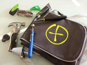 Eine braune Tasche und drumherum liegt Werkzeug