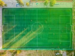 Ein Fußballfeld auf dem Menschen spielen aus der Vogelperspektive