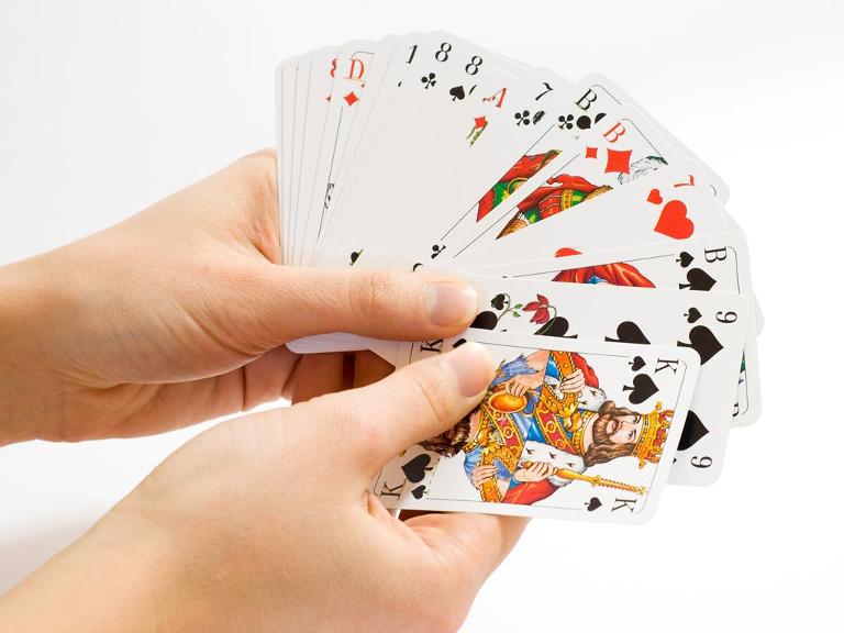 Zwei Hände halten mehrere Karten