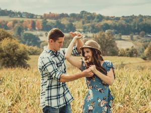 Mann und Frau halten sich an den Händen und tanzen auf einer Wiese