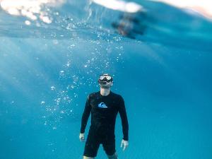 Ein Mensch mit Taucherbrille und Schorchel unter Wasser