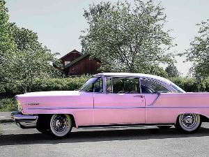 Ein rosafarbener Cadillac steht auf der Straße- Seitenansicht