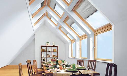Dachschräge mit großen Dachfenstern Esstisch mit Stühlen und Regal