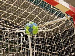 Ein Handball liegt auf dem Netz eines Tores