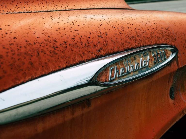 Chevrolet Schriftzug auf einem orange-verrosteten Auto