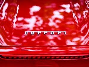 Silberner Schriftzug Ferrari auf einem roten Auto, Nahaufnahme