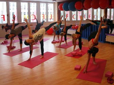 Yogagruppe - Menschen machen zusammen Yogaübungen