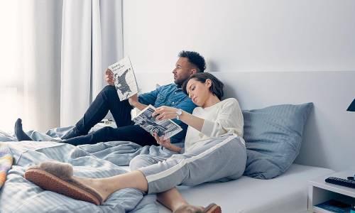 Mann und Frau auf einem Bett beim Lesen